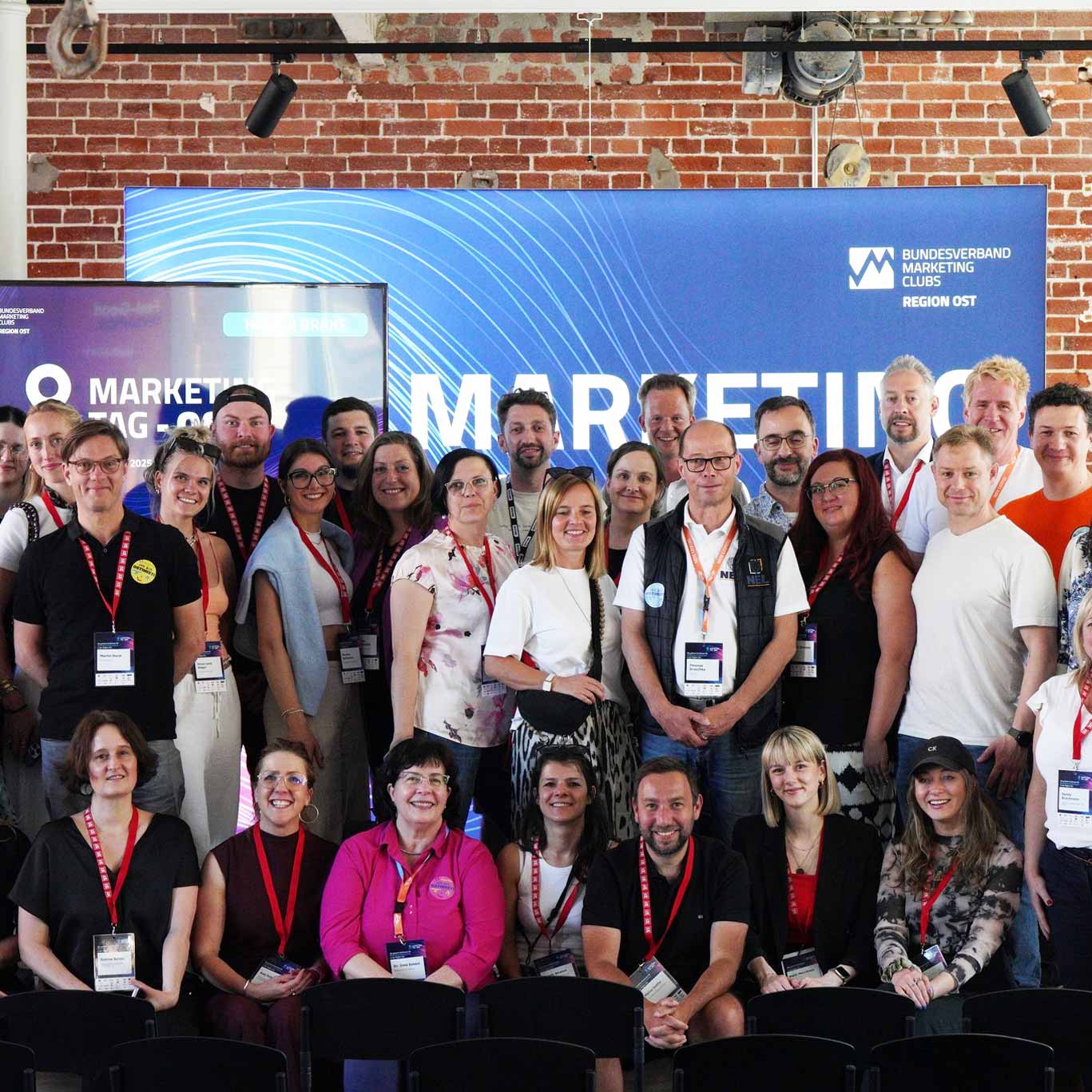 A group photograph of marketing event participants wearing name badges.