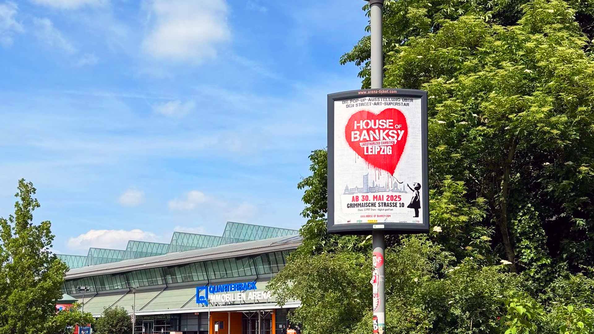Plakat für die Banksy Ausstellung in Leipzig mit Herzmotiv und Veranstaltungsdetails.