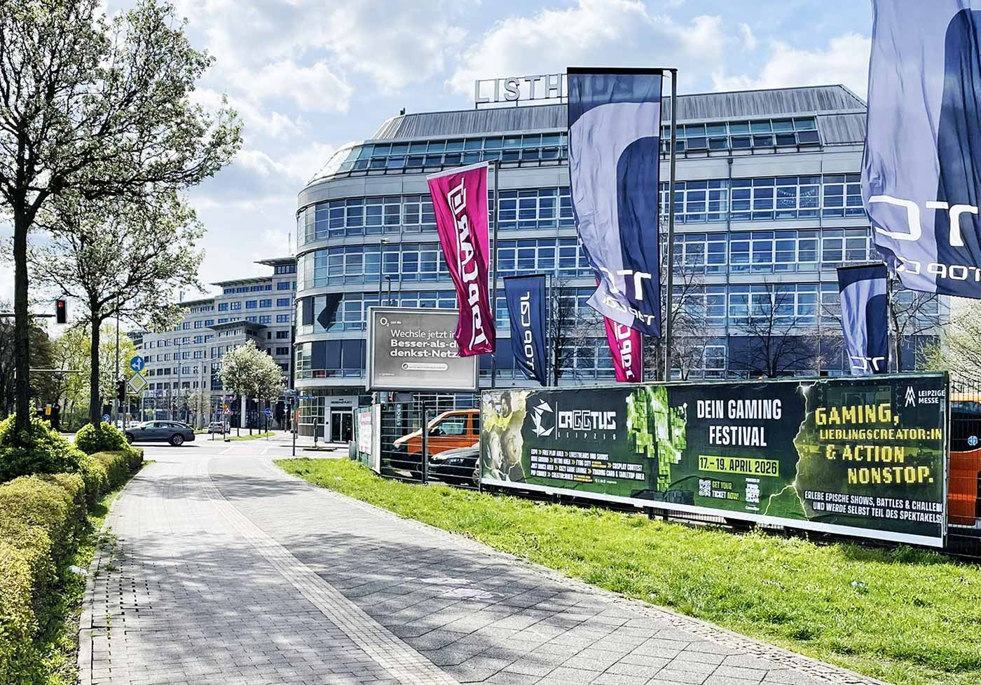 Vor der Leipziger Messe sind großflächige Stadtbanner für CaGGtus Leipzig zu sehen, mit Texten wie „Dein Gaming Festival“ und „17–19. April 2026“ in Blau und Grün.